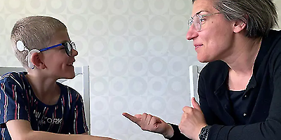 Kvinna och pojke kommuncerar med teckenspråk