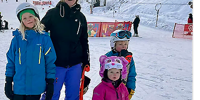 Barn med vuxen i skidområde